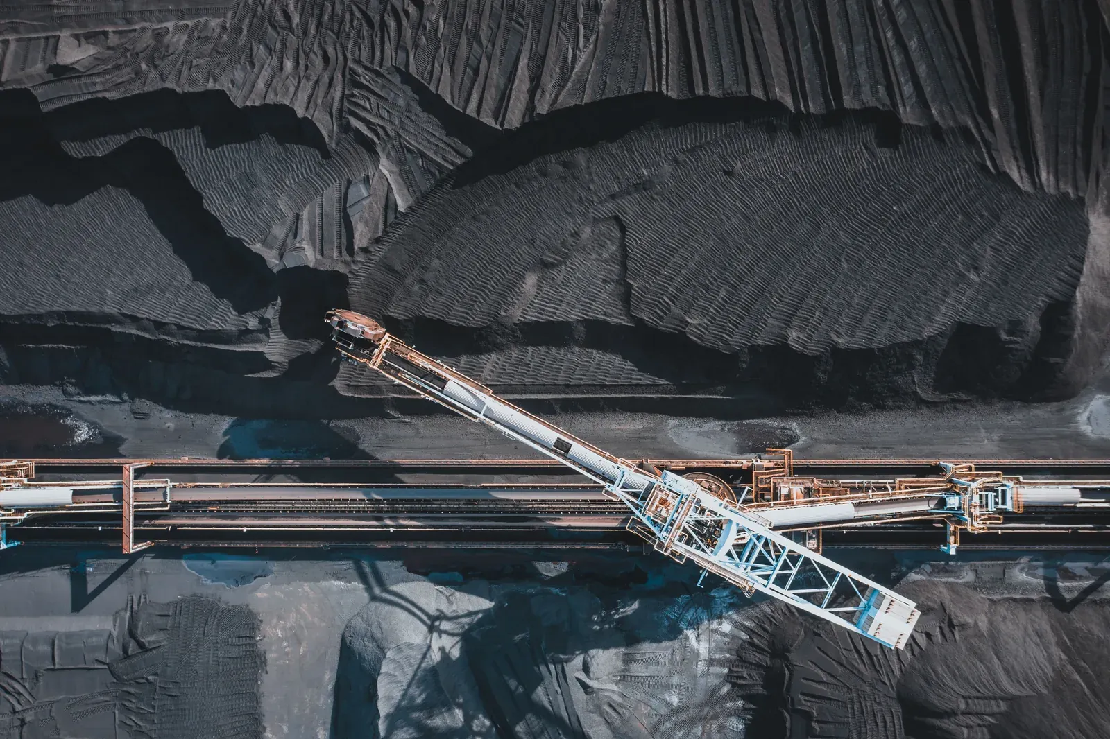A stacker-reclaimer between coal stockpiles, seen from above